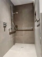 Ein modernes, barrierefreies Bad – elegante Fliesen, ebenerdige Dusche und stilvolles Design.