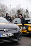 Kollegen tauschen sich zwischen den Fahrzeugen aus